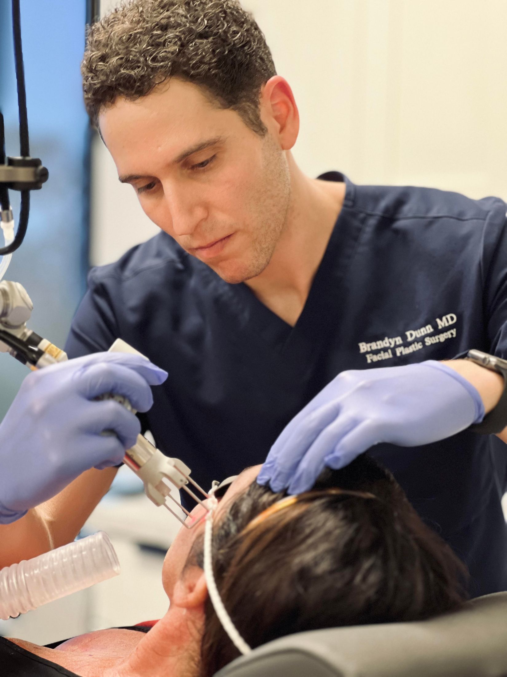 Newport Beach plastic surgeon performing facial treatment on a patient.